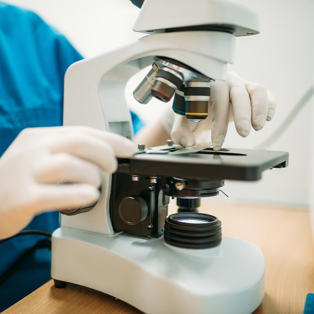 Doctor Putting Slide Under Microscope